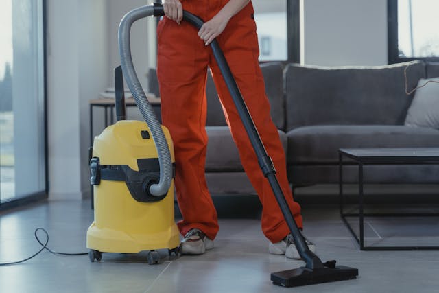 Person wearing headphones while mopping a living room